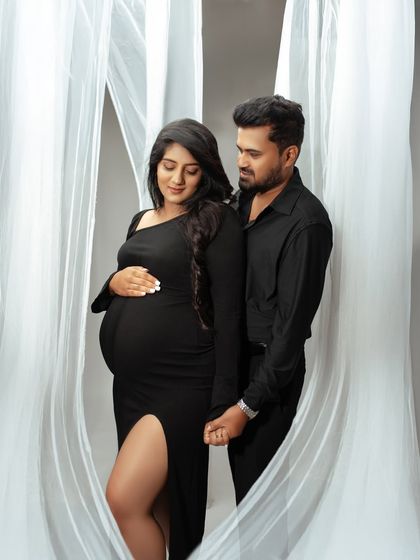 A classic and elegant couple's portrait. Dressed in all black, their connection is the focus, framed by soft white drapes for a modern and timeless feel.