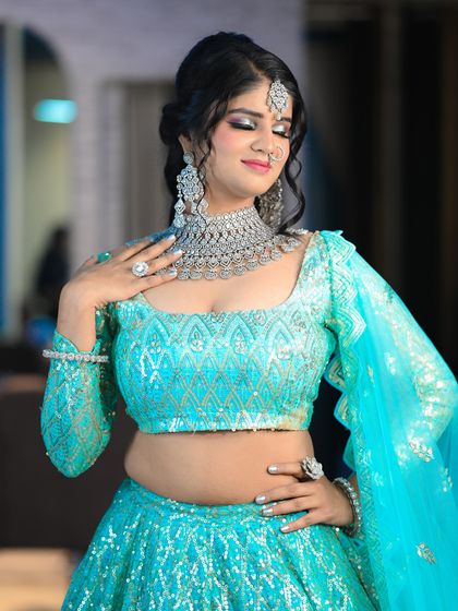 A graceful pose showing off the sequined lehenga and the bride's elegant makeup.