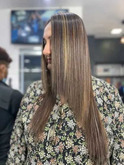 Here you can see the combination of highlights and a straightening treatment. The hair is not only frizz free but also has beautiful dimension, thanks to the carefully placed color.