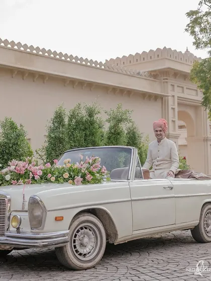 The groom, James, awaits the start of his baraat in a vintage Mercedes in Udaipur. It’s a classic, stylish shot that sets the tone for an elegant destination wedding.