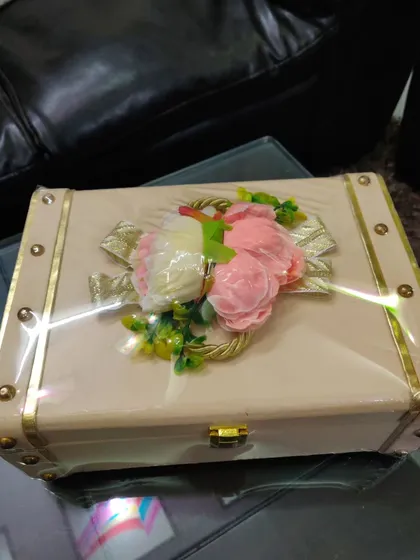 A beautifully decorated trunk box with floral arrangements on top, ready for gifting. This shows how I add a personal touch to each hamper.