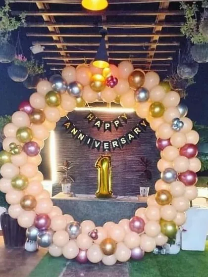 A first anniversary celebration on a beautiful terrace. I used a ring of peach, gold, and silver balloons to frame the "Happy Anniversary" banner and a large foil '1' balloon, making the most of the lovely outdoor space.