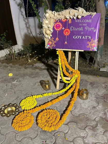 A close up of the welcome sign for a Diwali party. We combined a modern pampas grass arrangement with traditional marigold garlands for a unique look.