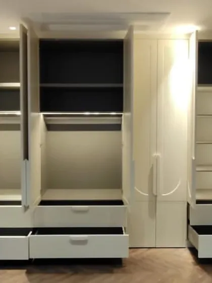 The interior of this wardrobe is just as impressive as its exterior. We incorporated sensor-activated LED strip lighting, multiple drawers for small items, and a mix of hanging spaces and adjustable shelves for complete organization.