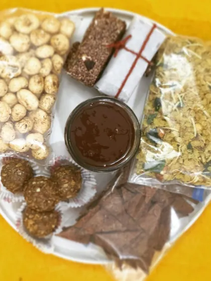 My travel-friendly snack platter, featuring spiced makhana, millet flakes mixture, gluten-free nachos, nutritional bars, and hazelnut nutella. Healthy eating, wherever you are.