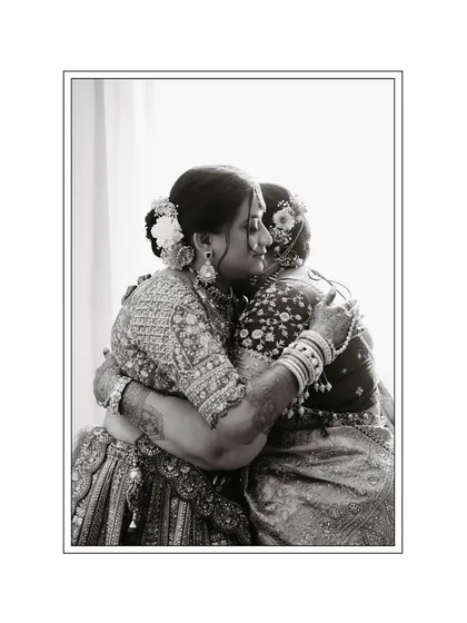 A touching black and white photo of the bride sharing a warm hug with her mother, capturing a moment of deep emotion.