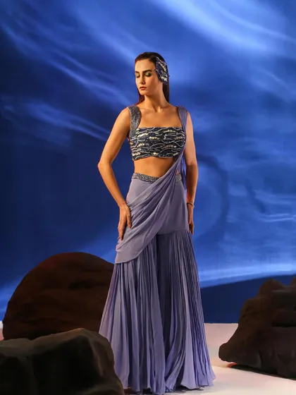 A full-length view of a lavender sharara set with a pre-draped dupatta. The styling is modern and fresh, perfect for a contemporary ethnic wear brand.