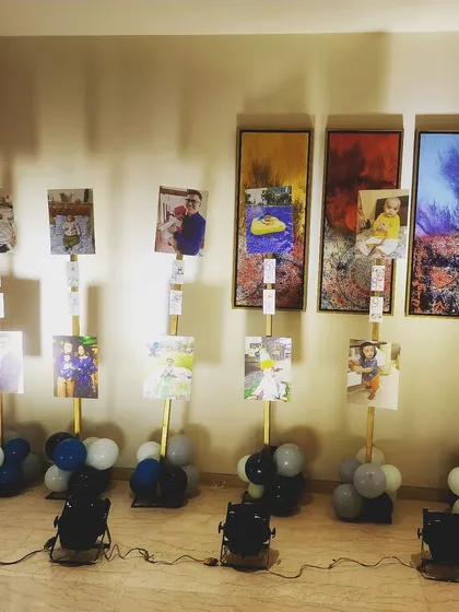A creative way to display a child's monthly milestone photos. Each photo is mounted on a stand with balloons at the base, creating a beautiful gallery walk for guests.