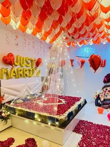 I specialize in creating romantic surprise decorations for your special moments. This "Just Married" bedroom setup includes a ceiling full of red and white balloons, a light-up canopy over the bed, heart-shaped foil balloons, and rose petals for a truly unforgettable experience.