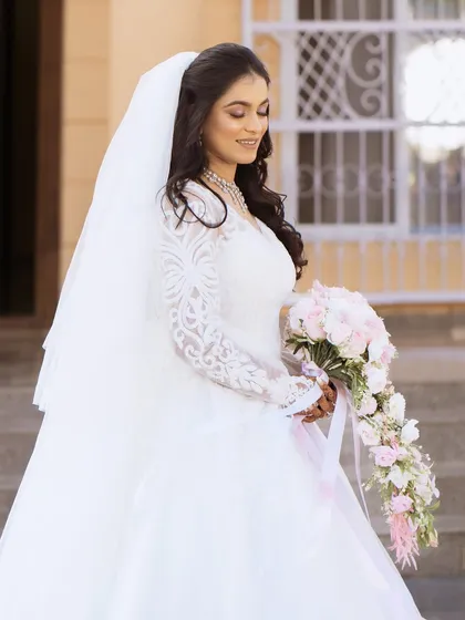 A side profile of the bride, showcasing her elegant dress and veil.