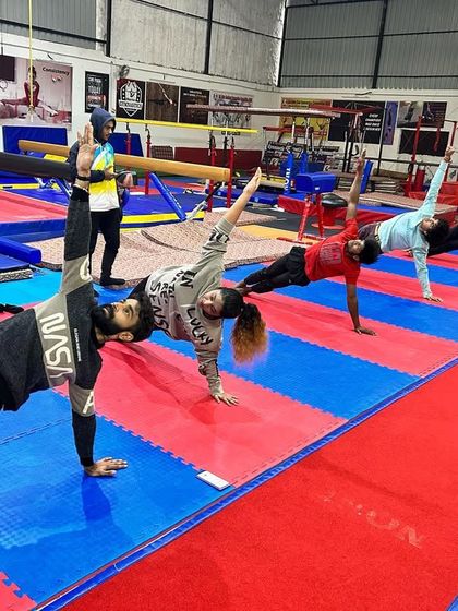 Adult students hold a side plank with a leg lift, a challenging core stability exercise. We focus on full-body functional fitness in our group classes.