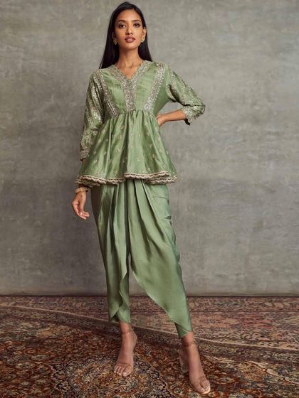 A beautiful fusion of styles in sage green. This set features a peplum-style kurta with delicate embroidery, paired with modern draped dhoti pants for a chic, comfortable look.