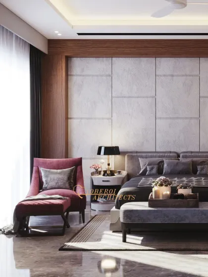 A pop of rich pink in the armchair adds a touch of warmth and personality to the otherwise neutral and calming bedroom design.