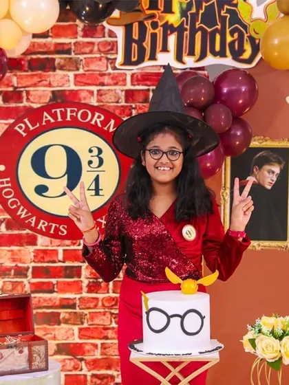 A young wizard ready for her party! We capture portraits that embrace the fun of the theme, like this shot with the Sorting Hat and a Golden Snitch cake.