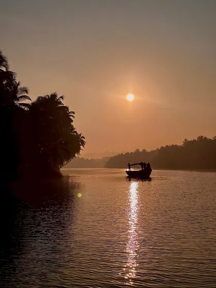 The beauty of nature during a boat ride in Honnavar, with the sun setting over the calm backwaters.