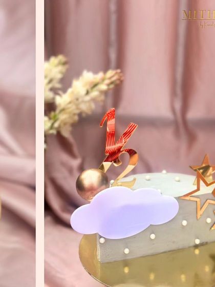 A whimsical cake for a half-birthday celebration. The design features a soft grey frosting, gold stars, a cloud accent, and a custom "1/2" topper, perfect for celebrating the little milestones.