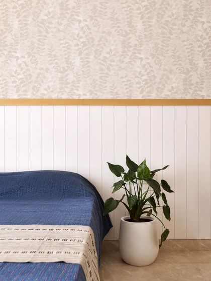 The guest room features a shiplap headboard panel with a veneer top beading, and a subtle wallpaper within the panels to add texture and visual interest.