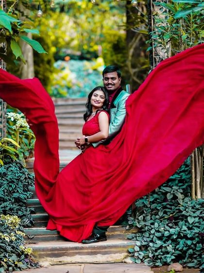 This pre-wedding shot uses the "flying" red trail to create a dynamic and artistic composition in a lush green setting.