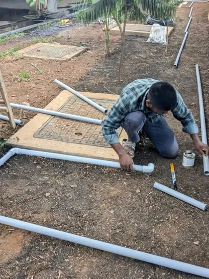 A team member assembles the PVC pipes and fittings for the irrigation system before placing them in the trenches.