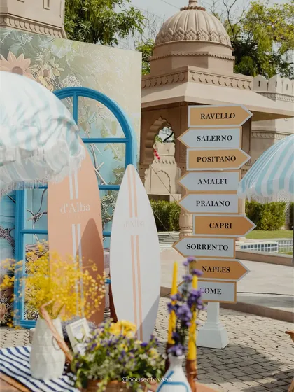 A fun directional signpost pointing to various Italian coastal towns, adding a whimsical and thematic detail to the Positano-inspired Mehendi.
