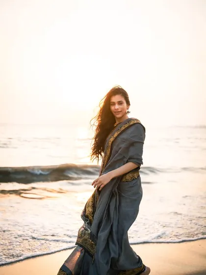 A full-length shot of the saree flowing in the sea breeze. This captures movement and the elegance of the attire against the waves.