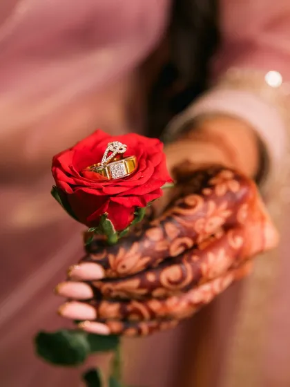 The wedding rings, symbols of a lifelong promise, resting on a single red rose. We believe in capturing the small details that hold immense meaning.
