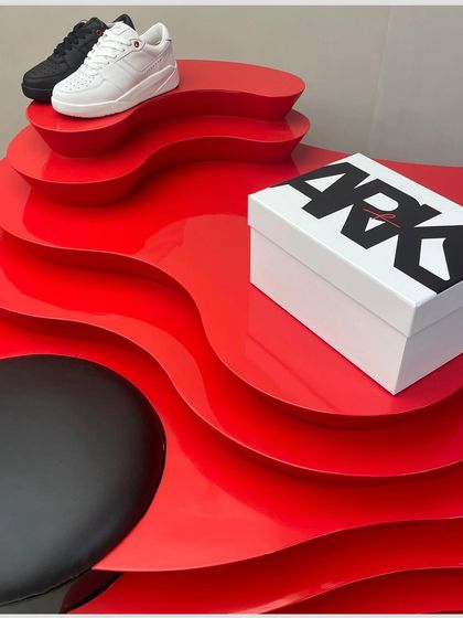 Another angle of the vibrant red display unit, showing how it serves as both a functional shoe display and a sculptural focal point.