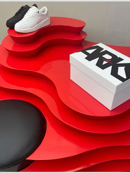 Another angle of the vibrant red display unit, showing how it serves as both a functional shoe display and a sculptural focal point.
