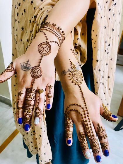 This modern design incorporates the client's existing tattoos of a crown and a heart. The delicate chains and motifs are designed to complement and enhance her personal style.