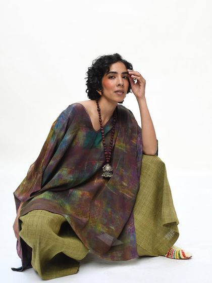 A powerful, direct portrait for Wandering Silk. The model's confident pose and the rich, earthy tones of her outfit are captured straight from the camera, showcasing a raw and untouched beauty.