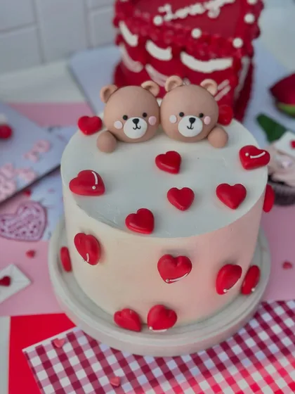 An adorable Valentine's cake featuring two cute teddy bears surrounded by little red hearts.