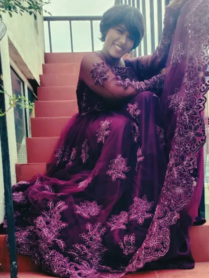A smiling shot on the stairs, showing the full detail of the gown.