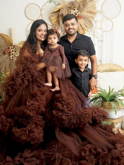 A beautiful family of four in coordinated brown outfits. The mother's flowing gown adds a touch of drama and elegance to this lovely boho-themed portrait.