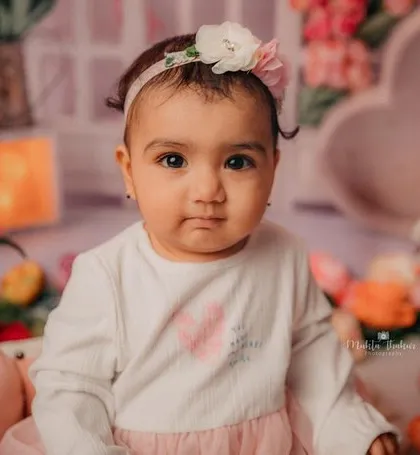 A beautiful portrait of this 8-month-old princess. The floral background and her sweet expression are a perfect match.