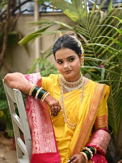 A closer look at this bride's radiant makeup, designed to complement her yellow Nauvari saree and traditional Maharashtrian jewelry. The focus is on a clean, glowing complexion and defined eyes.