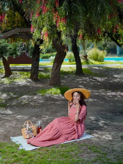 A wider shot of the picnic setup, establishing the peaceful and idyllic atmosphere of the entire fashion story.