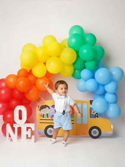 Reaching for the balloons! This action shot captures the excitement and energy of a first birthday celebration.