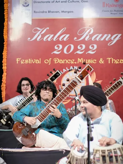 A smiling moment on stage during the Sitar Symphony concert in Goa. The joy of playing music is evident.