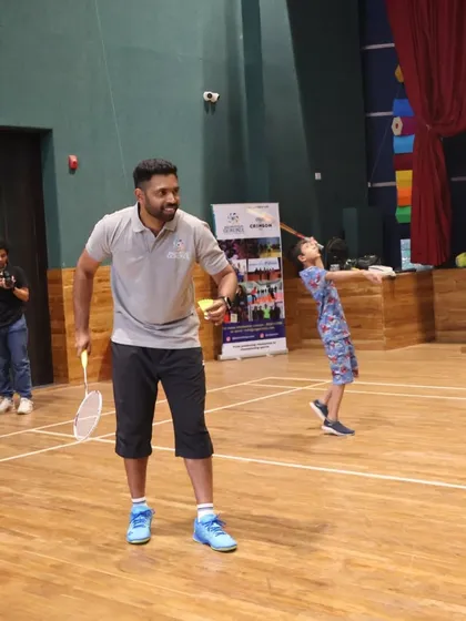 A fun and dynamic training moment where a coach engages with a young player during a drill.
