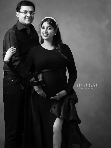 A full-length black and white portrait showcasing a dramatic gown. This image balances the couple's connection with high-fashion styling.