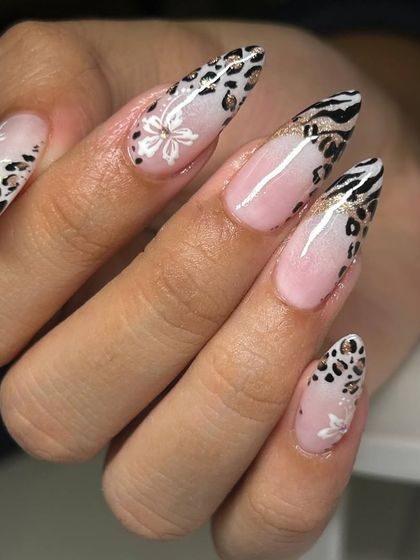 A bold and glamorous nail art design combining leopard and zebra prints. The look is finished with delicate white floral details and a touch of gold glitter for extra sparkle.
