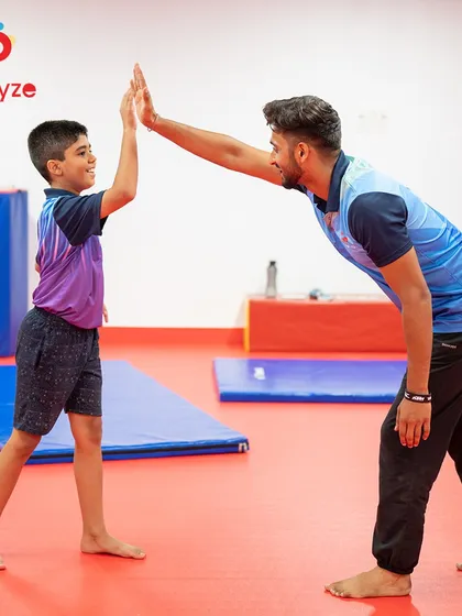 A high-five for a job well done. The bond between our coaches and students is at the heart of everything we do, creating a positive and encouraging atmosphere where every child feels like a champion.