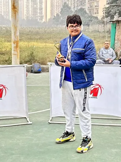 A player holding his trophy from the Winter League Championship. Every player gets a chance to shine.