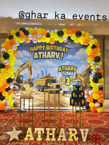 A wide shot of the construction party setup, showing the full balloon arch and marquee letters spelling out the birthday boy's name.
