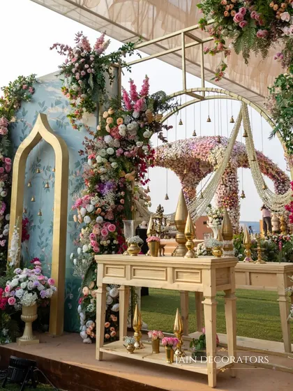 Another angle of the pastel-themed decor, showing the layers of floral arrangements, elegant furniture, and the stunning floral mandap in the background.