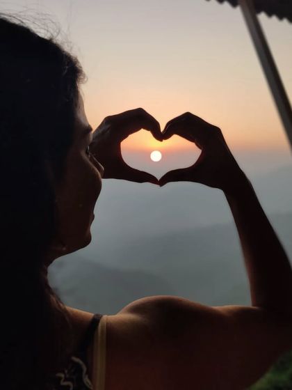 Making a heart with my hands around the setting sun, with my bicep flexed. I'm creating my own sunshine and loving the strength I've built.