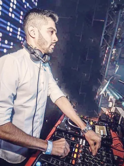 A clean, professional shot of me working the decks in a white shirt, with a large LED screen in the background. This demonstrates my experience playing in modern clubs with advanced visual setups.