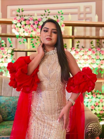 This beige gown with dramatic red ruffled sleeves is a statement piece. It's perfect for making a grand entrance at a Sangeet or cocktail party.