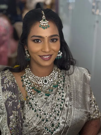 A smiling portrait of my Chennai bride Sruthi, looking radiant for her reception. Her makeup for her dusky skin tone is glowing and glamorous, paired with magnificent emerald and diamond jewellery.