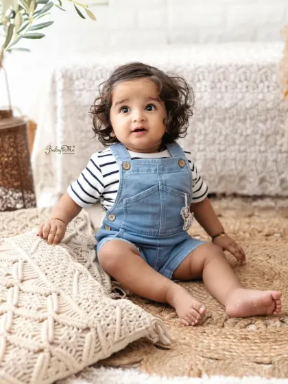 This little boy with the amazing curly hair is looking so stylish in his denim overalls. A simple, lifestyle setup like this is great for capturing a baby's natural charm.
